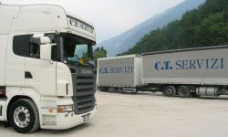 In secondo piano, camion con rimorchio